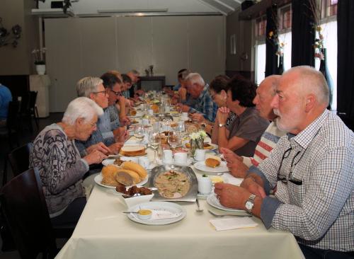 De deelnemers genieten van de lekkere koffietafel