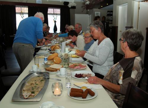 De deelnemers genieten van de lekkere koffietafel