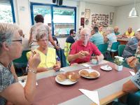 De organisator en fotograaf, rode trui, nu zelf even in beeld tijdens de lunch