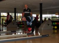 Eric gooit een bowlingbal terwijl Pieter hem in de gaten houdt