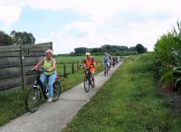 De zus van Frans voor het peloton aan op een smal landwegje